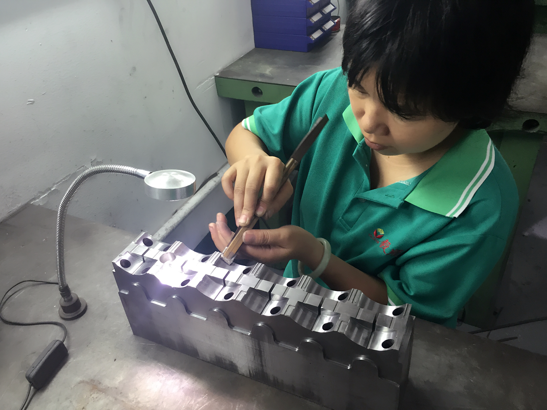 省模師傅正在用砂紙對模具進行省模工序，需確保去除火花紋、打磨平整、光潔度達到一定要求才能進下工序：拋光